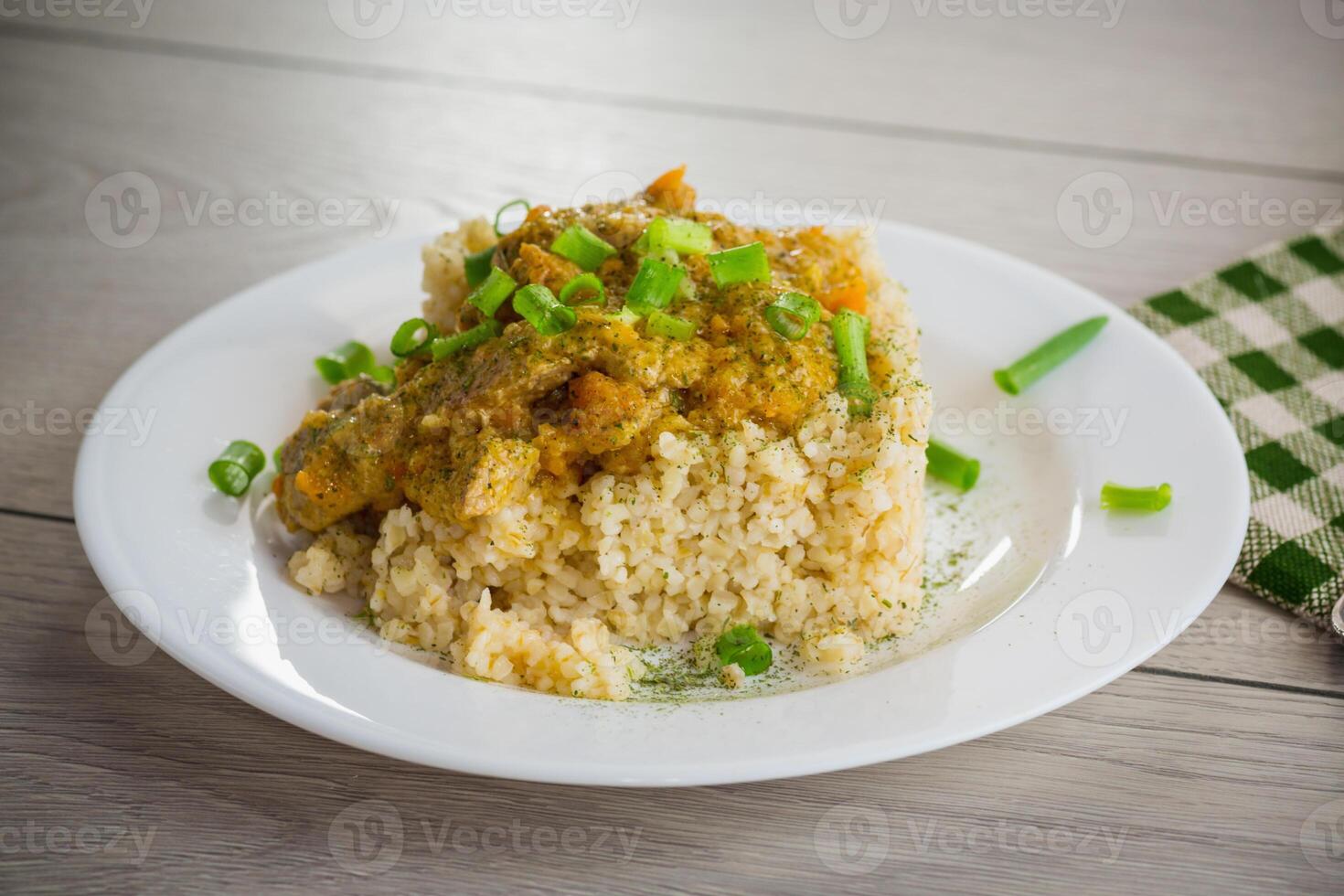 gekookt bulgur met vlees saus en groenten in een bord foto