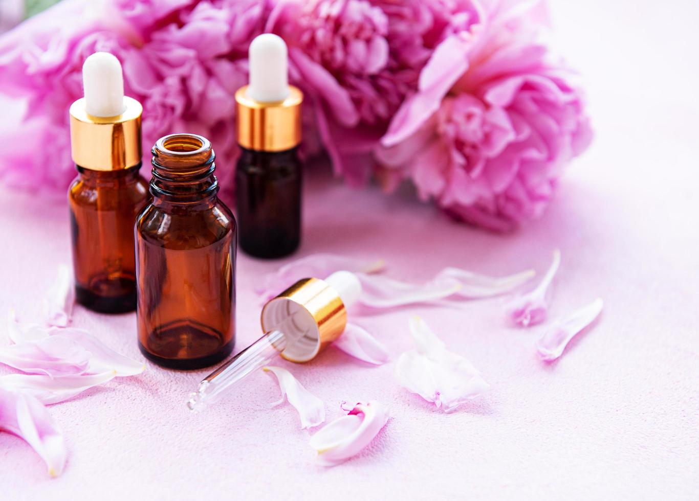 essentiële oliën voor aromatherapie en roze pioenrozen foto