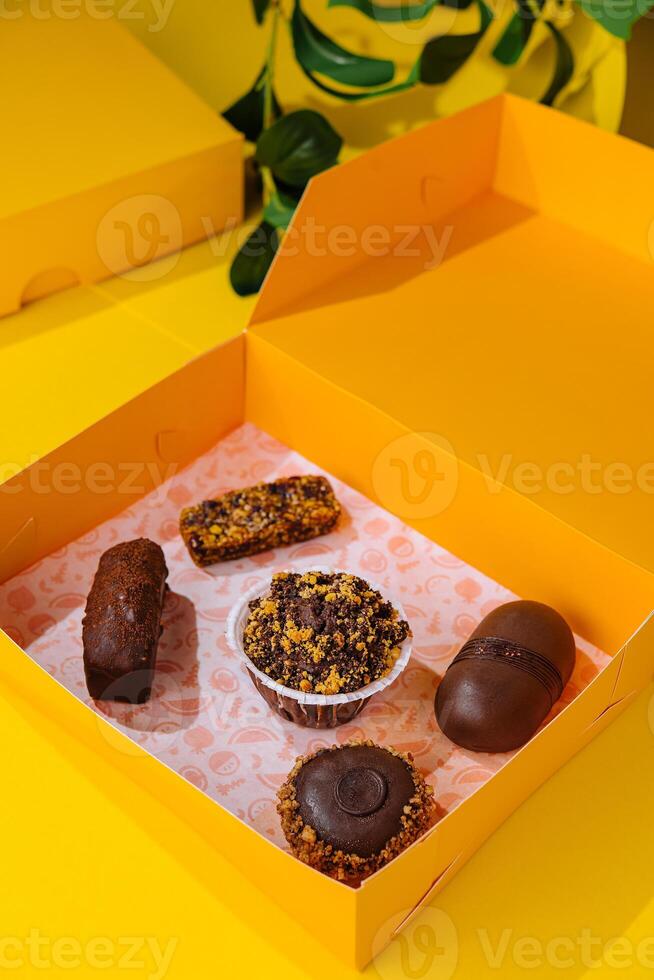 Kerstmis cadeaus presenteert met verschillend cakes Aan geel doos foto