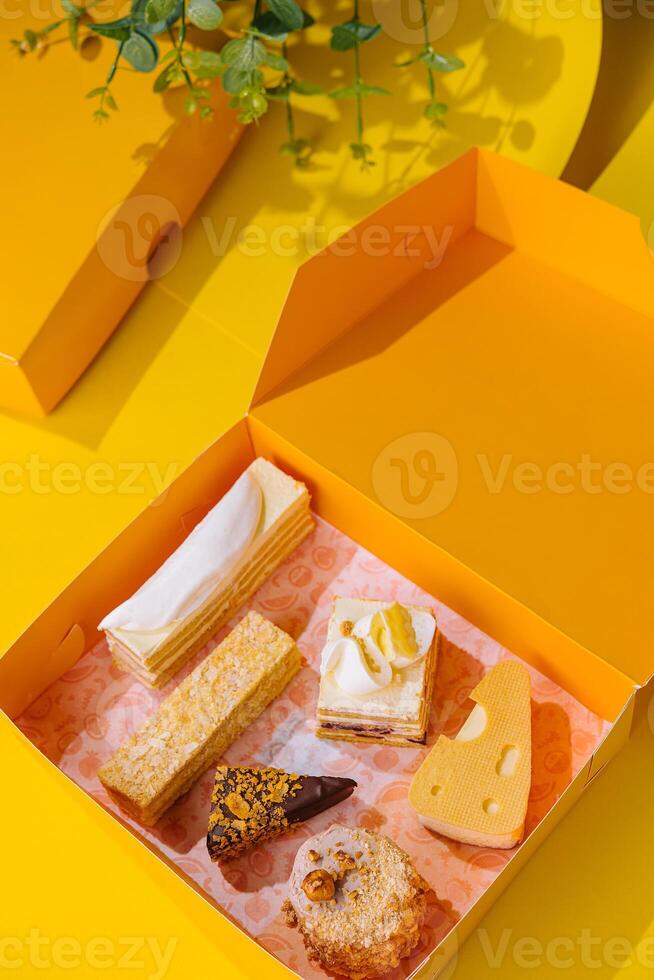 Kerstmis cadeaus presenteert met verschillend cakes Aan geel doos foto