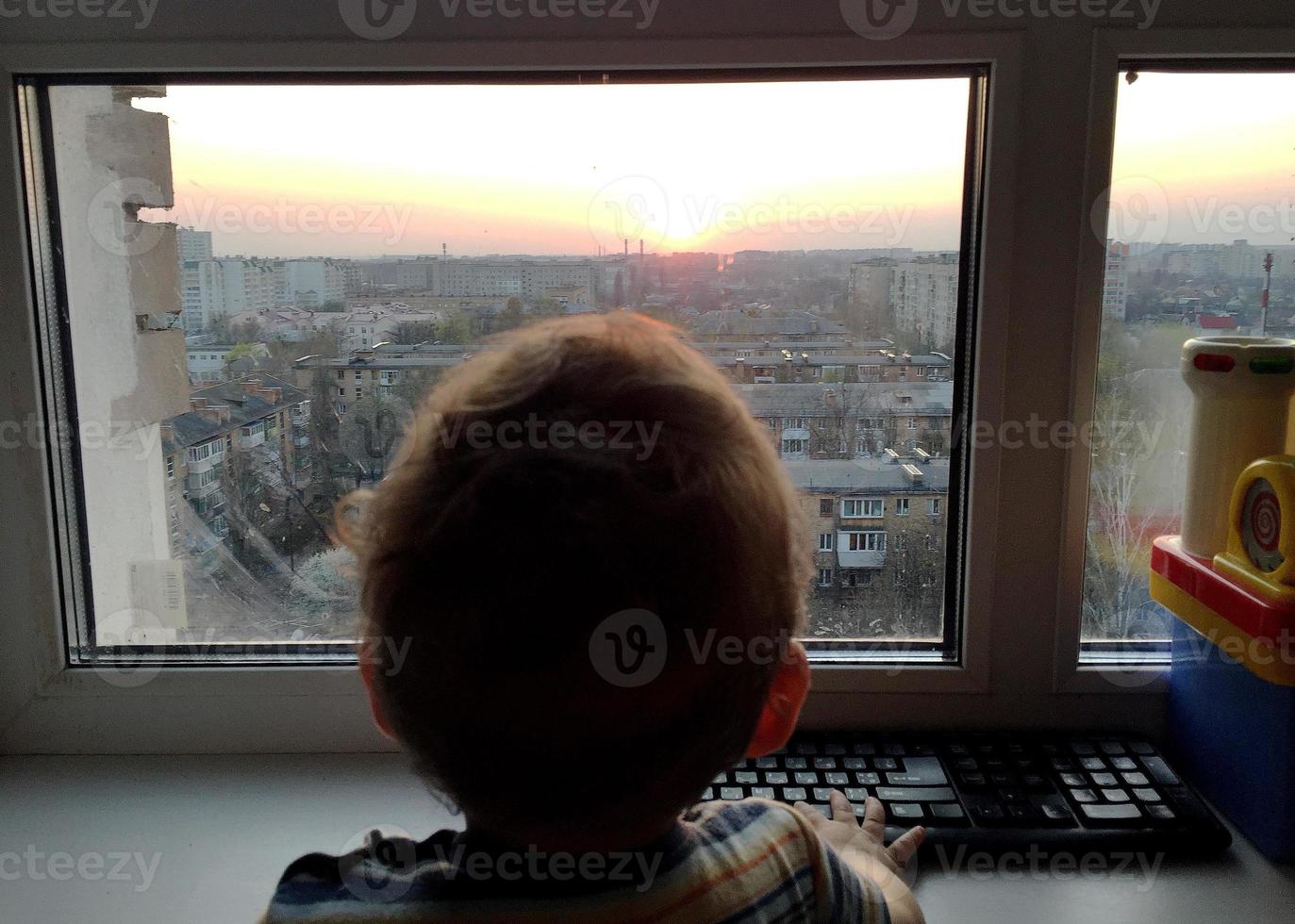 mooie babyjongen met kind gezicht poseren fotograaf in de buurt van raam foto