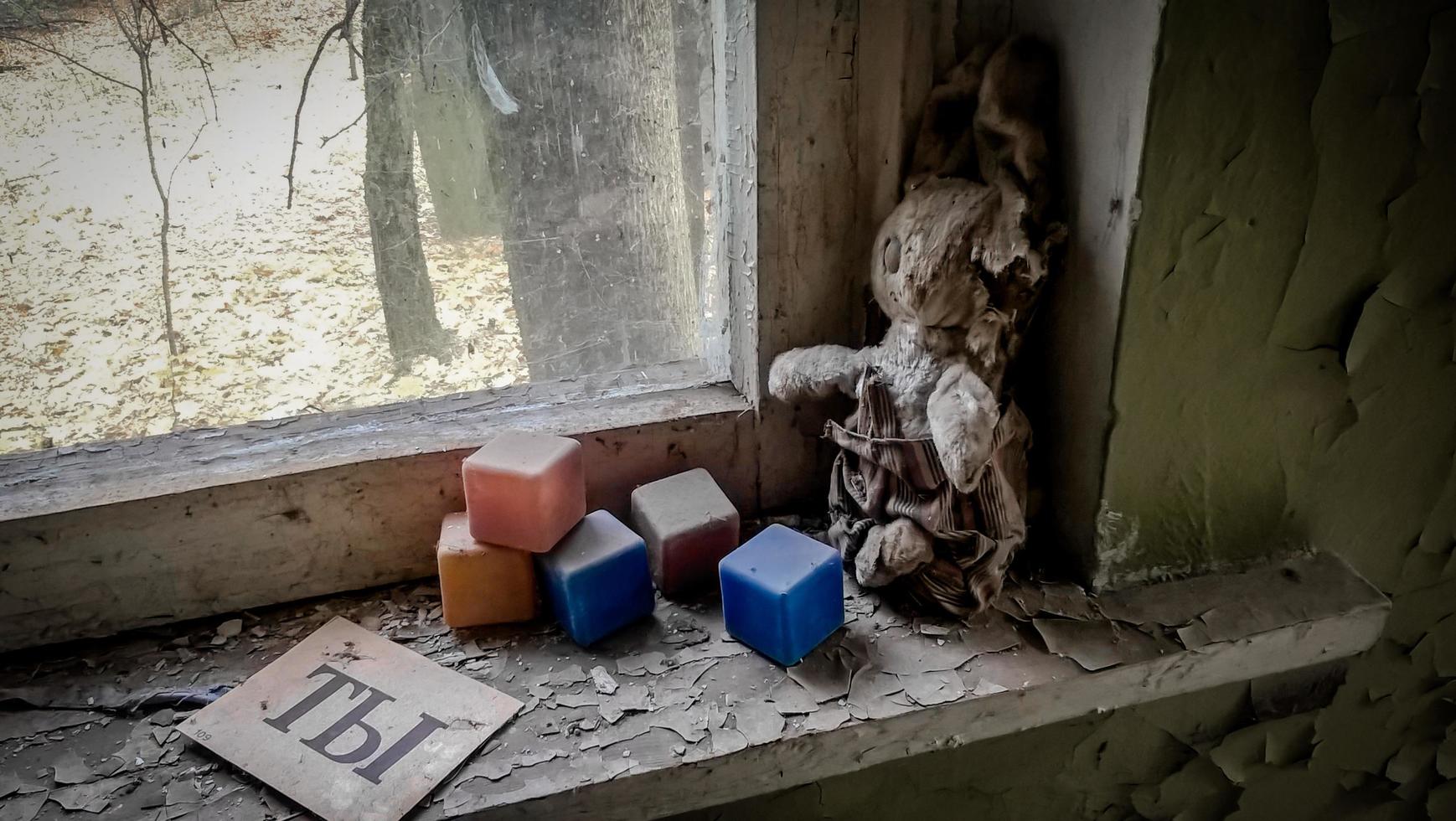 pripyat, oekraïne, 2021 - oude pop op een vensterbank in een verlaten huis in Tsjernobyl foto
