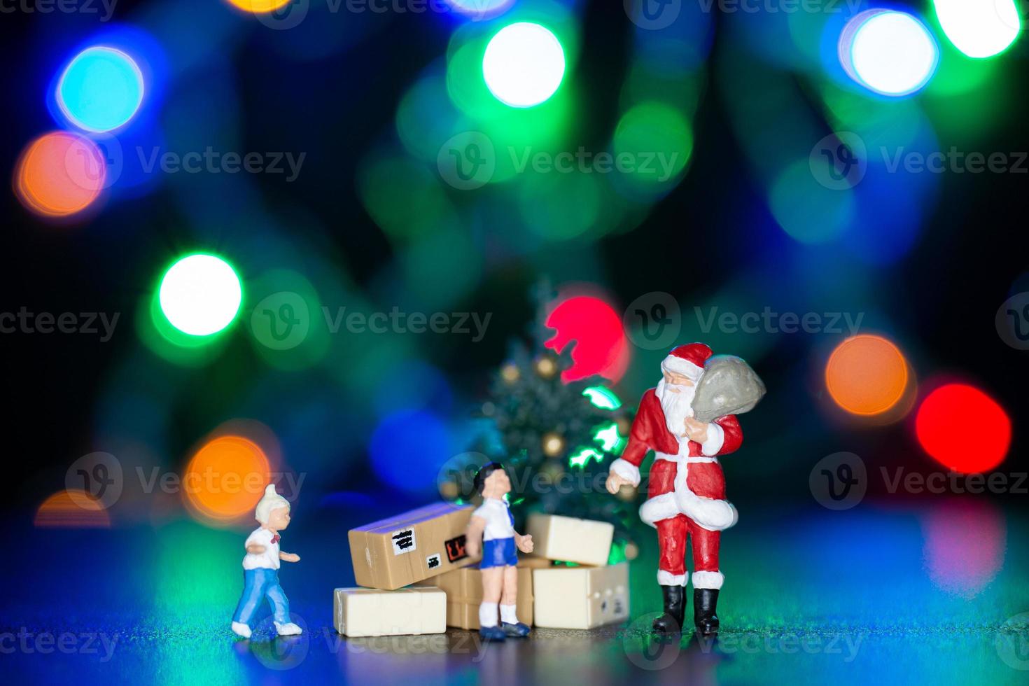 miniatuur mensen, kerstman levering geschenkdoos voor kinderen foto