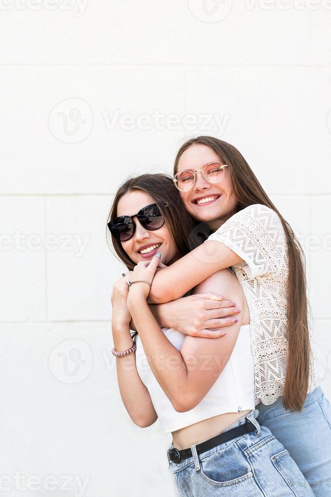 twee vriendinnen knuffelen buiten op een zomerse dag met plezier foto