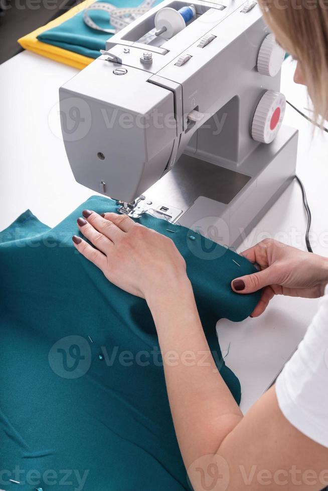 vrouw kleermaker naaien het textiel in haar atelier foto