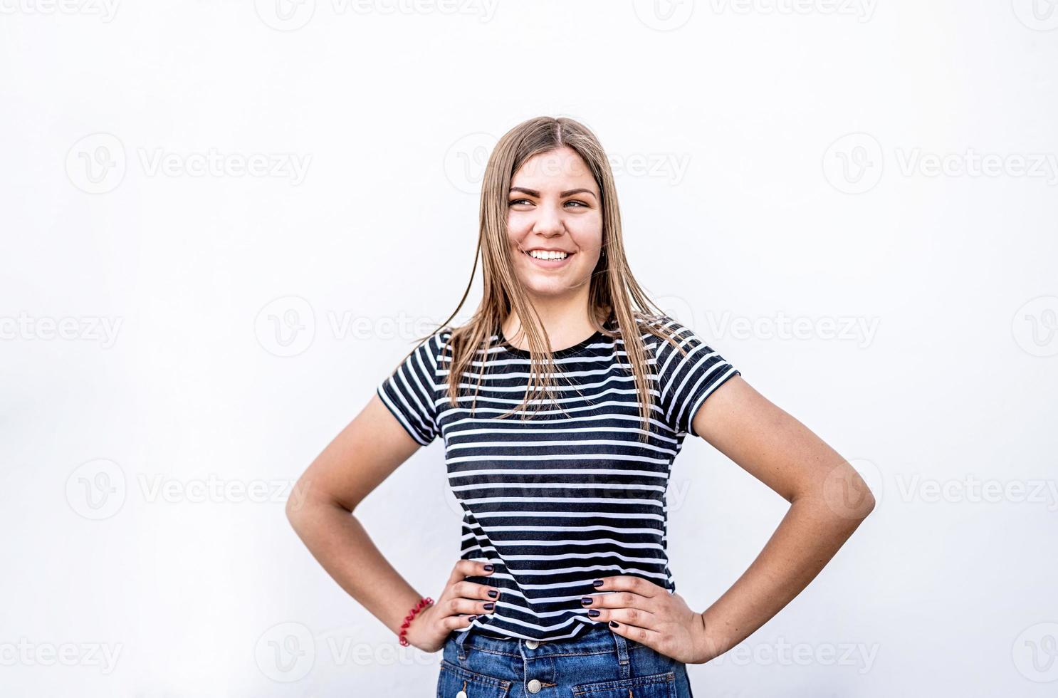 mooie lachende blanke vrouw met schone huid, natuurlijke make-up in vrijetijdskleding op grijze achtergrond foto