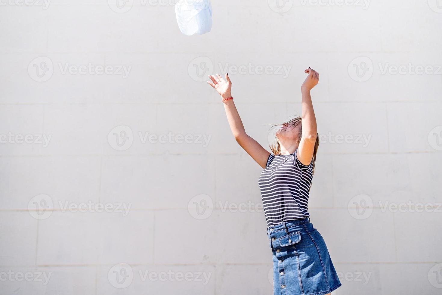 gelukkige jonge blanke vrouw die haar blauwe stof overgeeft en plezier heeft op een zonnige zomerdag foto