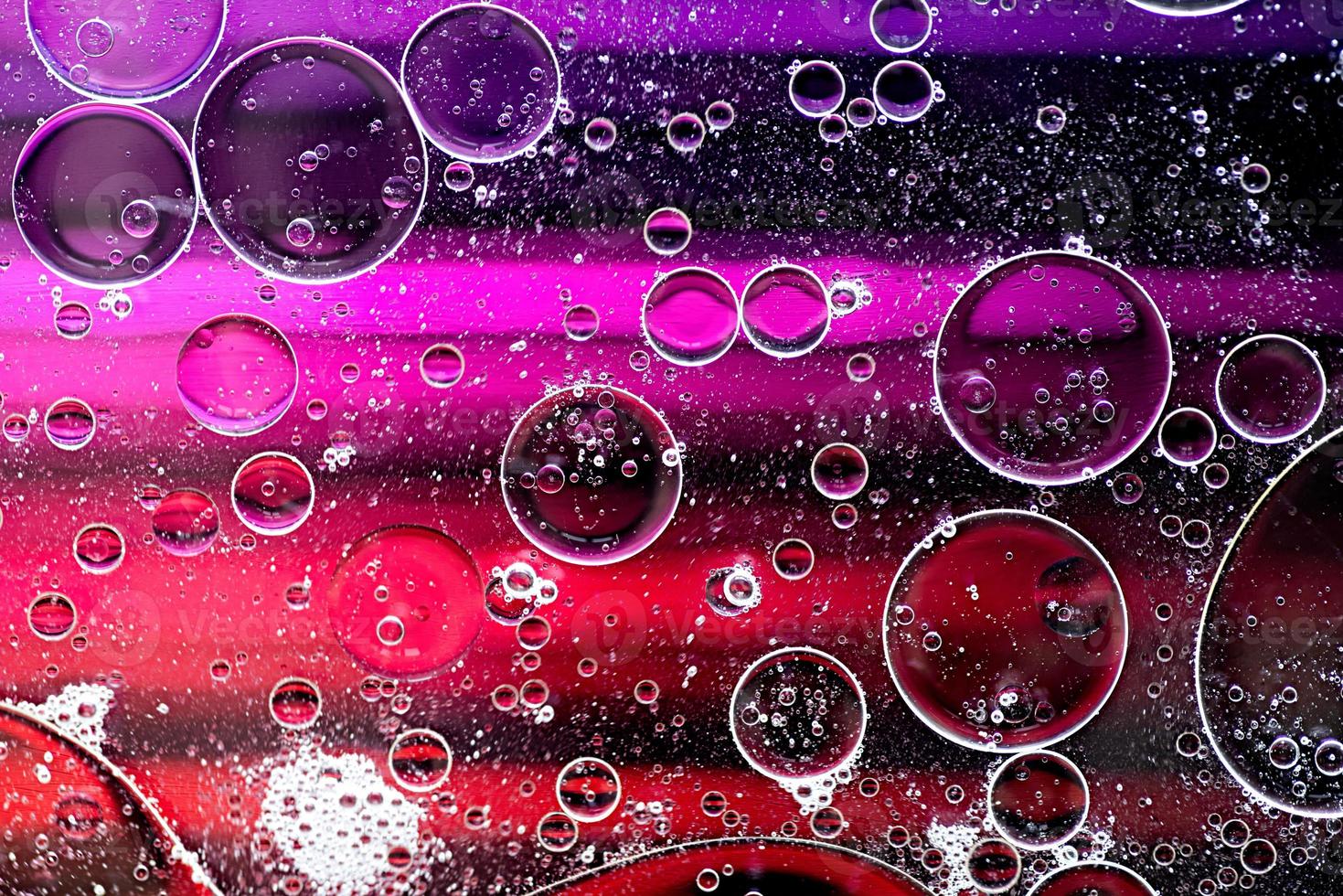 roze en paars abstract patroon gemaakt met oliebellen op water dat in beweging komt foto