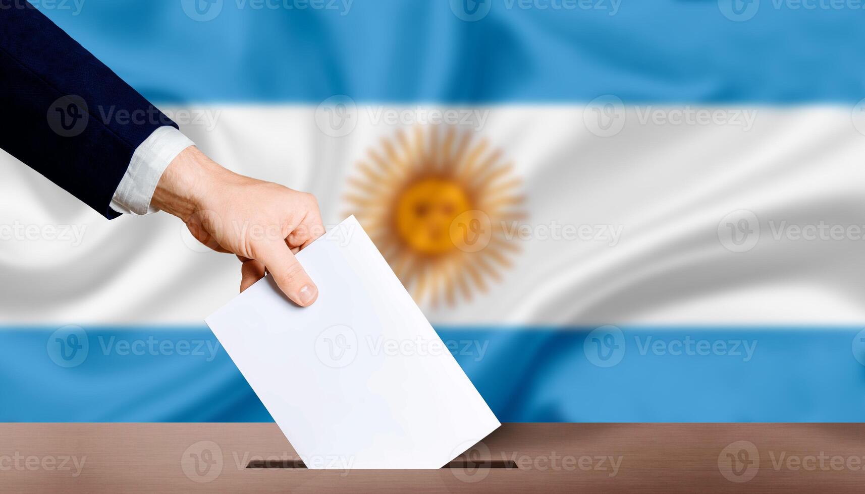 hand- Holding stemming in stemmen stemming doos met Argentinië vlag in achtergrond. hand- Mens zet stemming papier in stemmen doos Aan Argentinië vlag achtergrond. Argentinië electoraal verkiezingen, concept foto