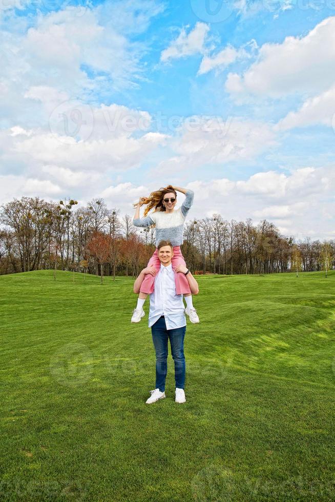 mooi jong stel in het park, ze zit op zijn schouders, het concept van mooie verliefde mensen foto