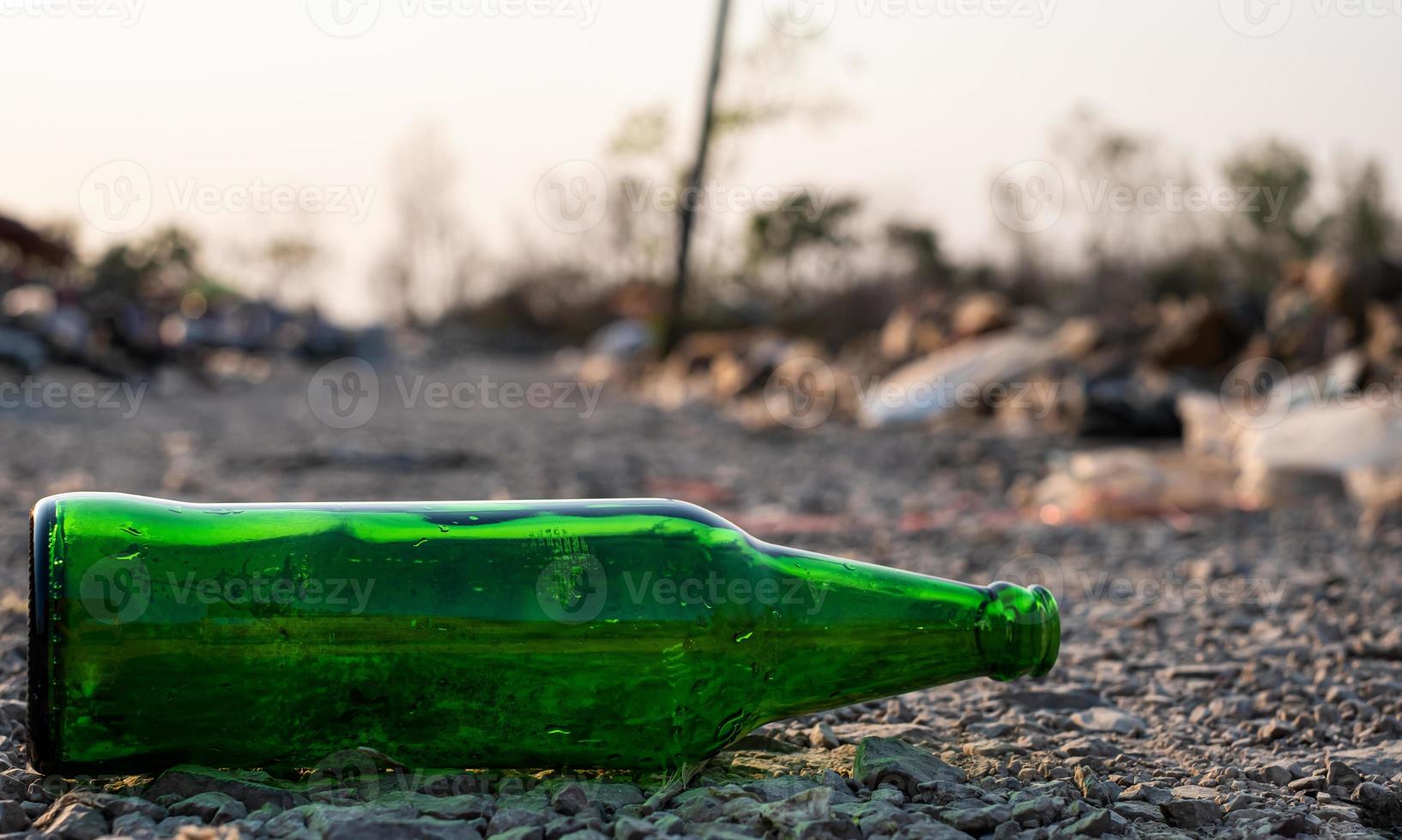 groene glazen fles op de grond op onscherpe achtergrond, foto