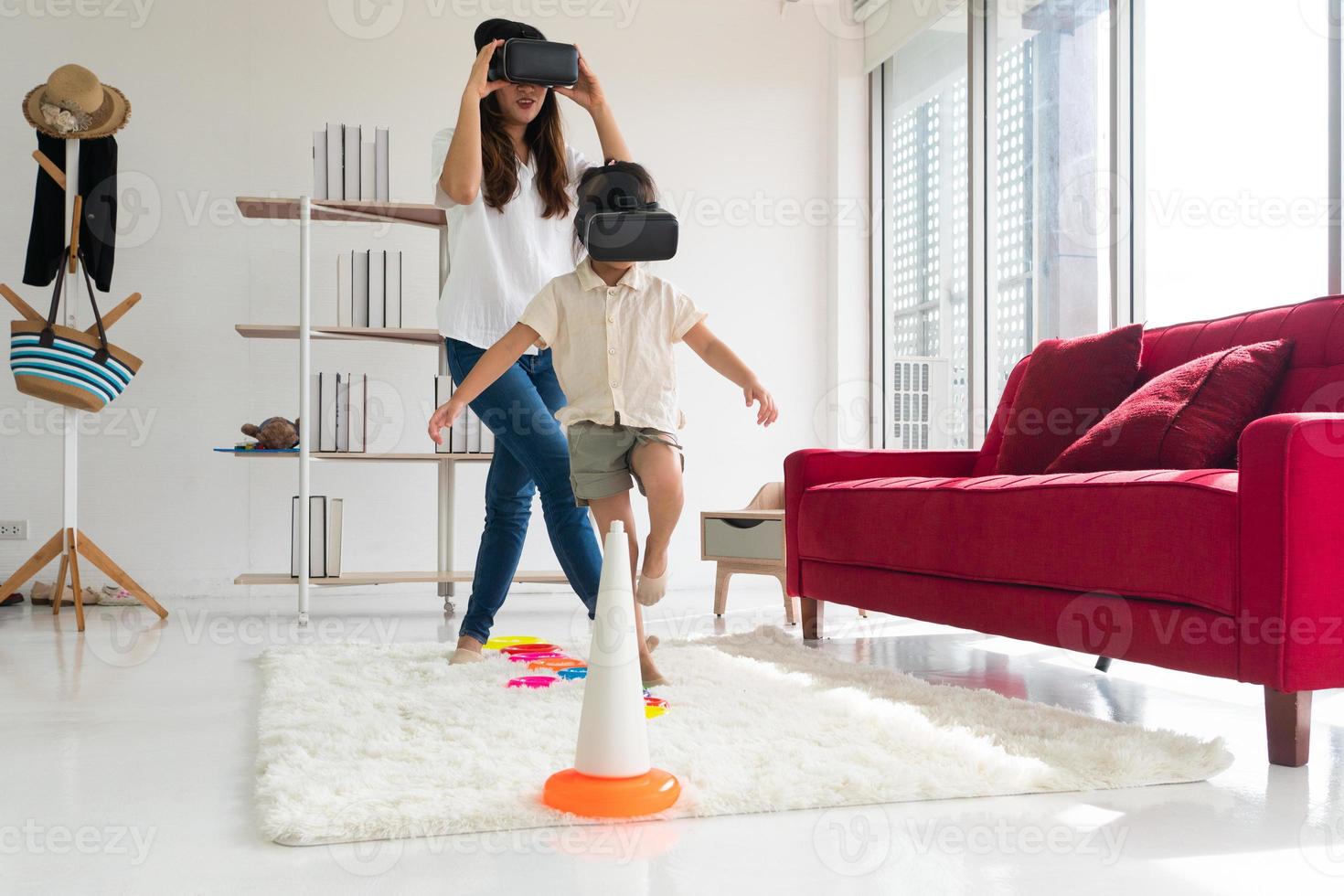 jonge aziatische jongen en moeder die thuis een virtual reality-spel spelen. familie samen concept foto