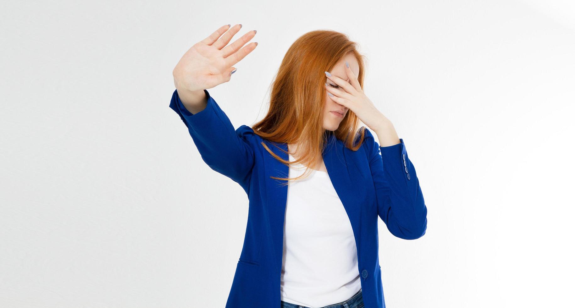 jonge roodharige vrouw die een afwijzing pose en facepalm op een witte achtergrond maakt. negatieve menselijke emotie gezichtsuitdrukking gevoel lichaamstaal foto