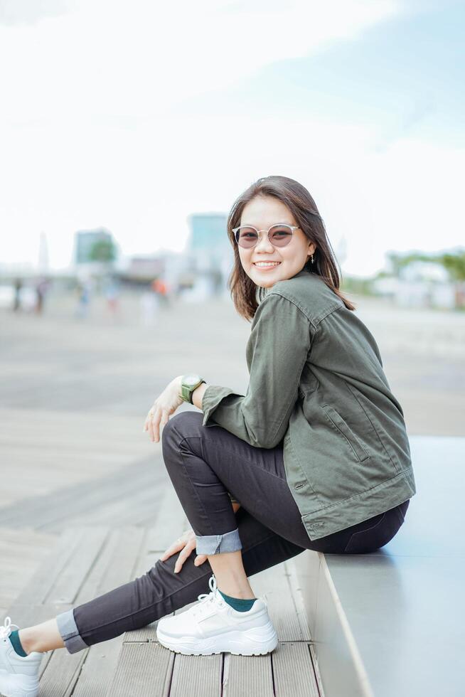 jong mooi Aziatisch vrouw vervelend jasje en zwart jeans poseren buitenshuis foto