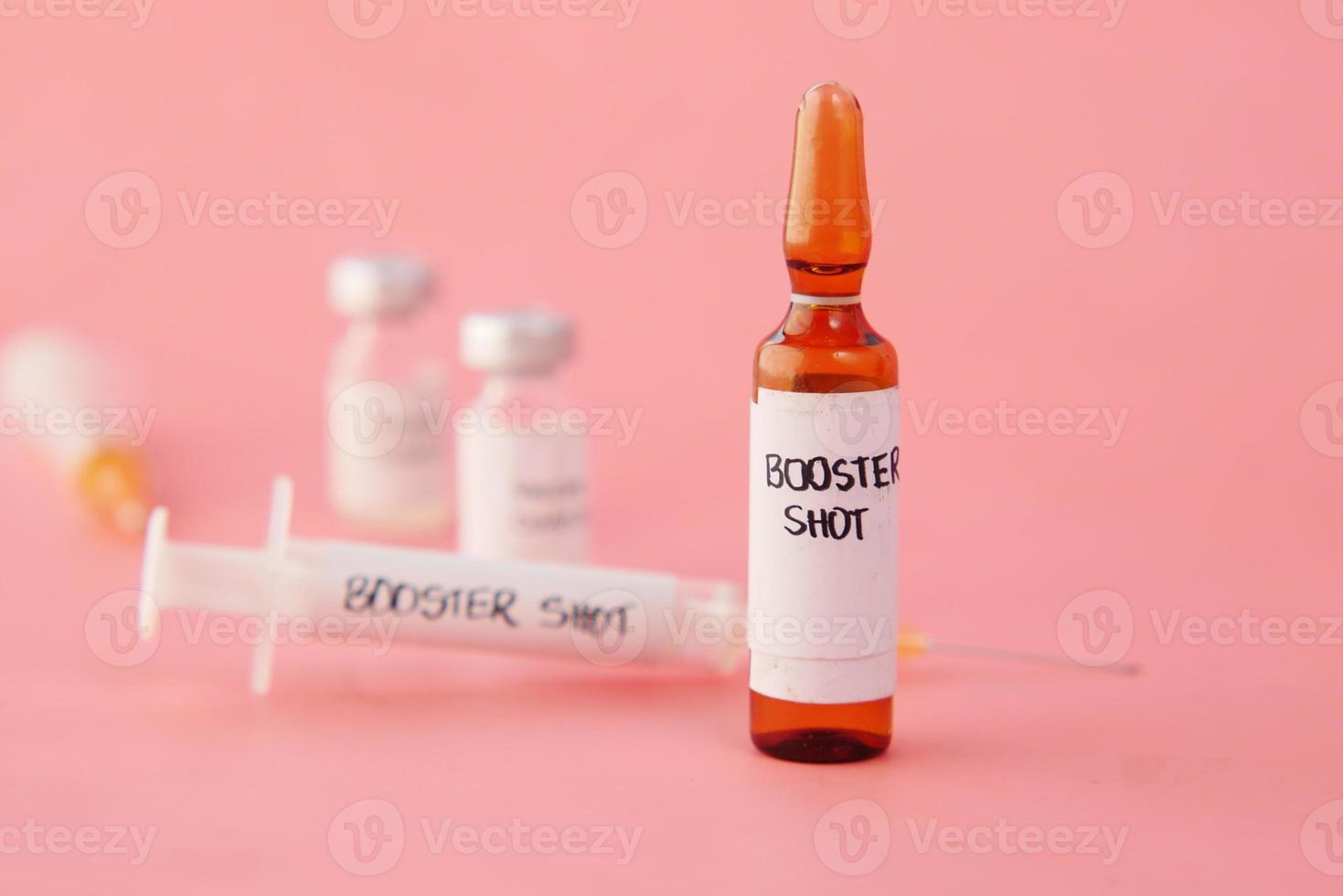 booster shot dosis coronavirusvaccin en spuit op roze foto