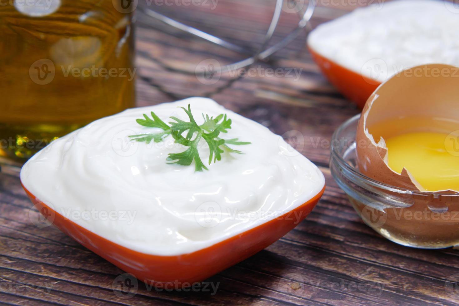 mayonaise in container, olie en eieren op tafel foto