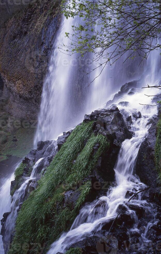 een waterval is vloeiende naar beneden een rotsachtig heuvel foto