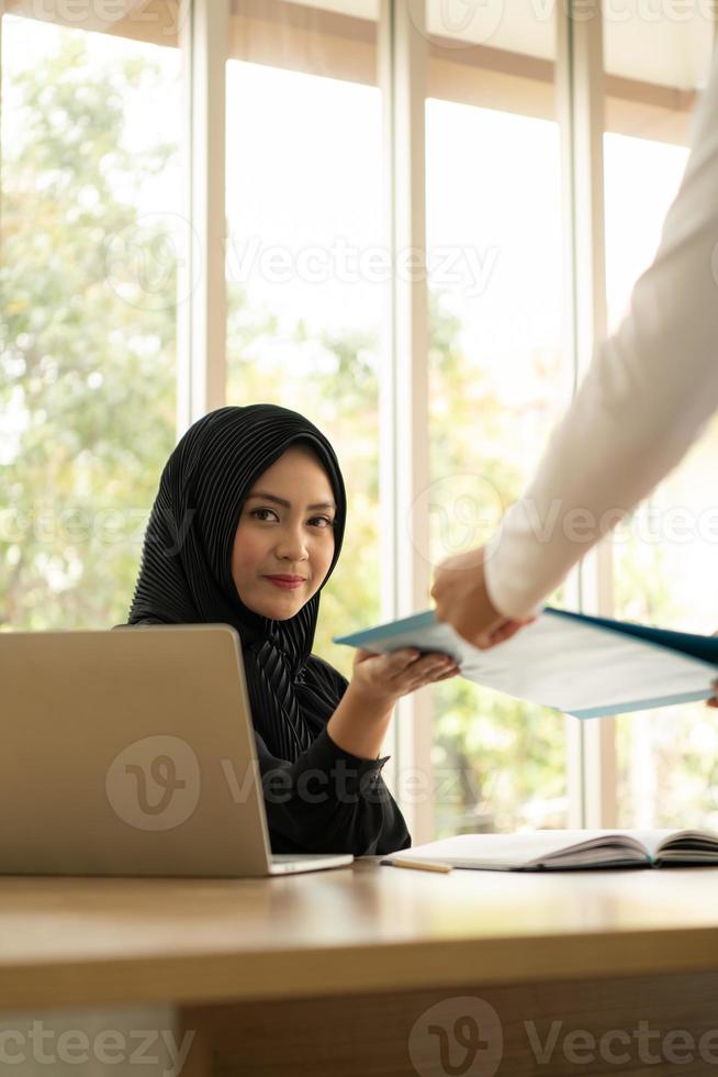 Arabische zakenvrouw die hijab draagt, werkt op kantoor foto