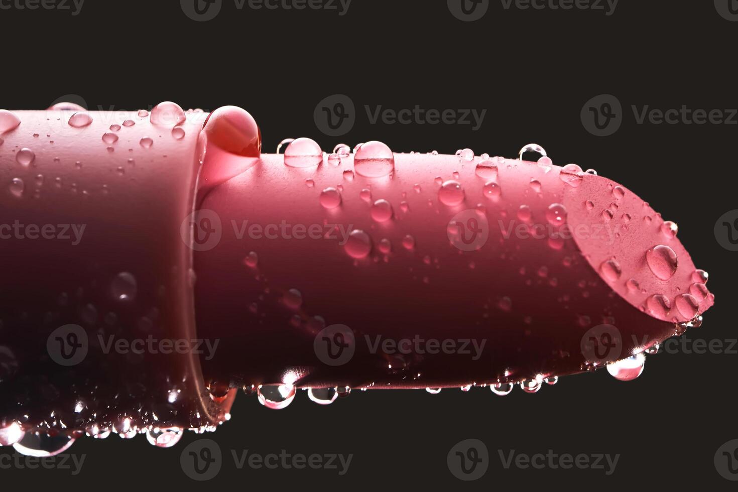 rood lippenstift met water druppels Aan een donker achtergrond. foto