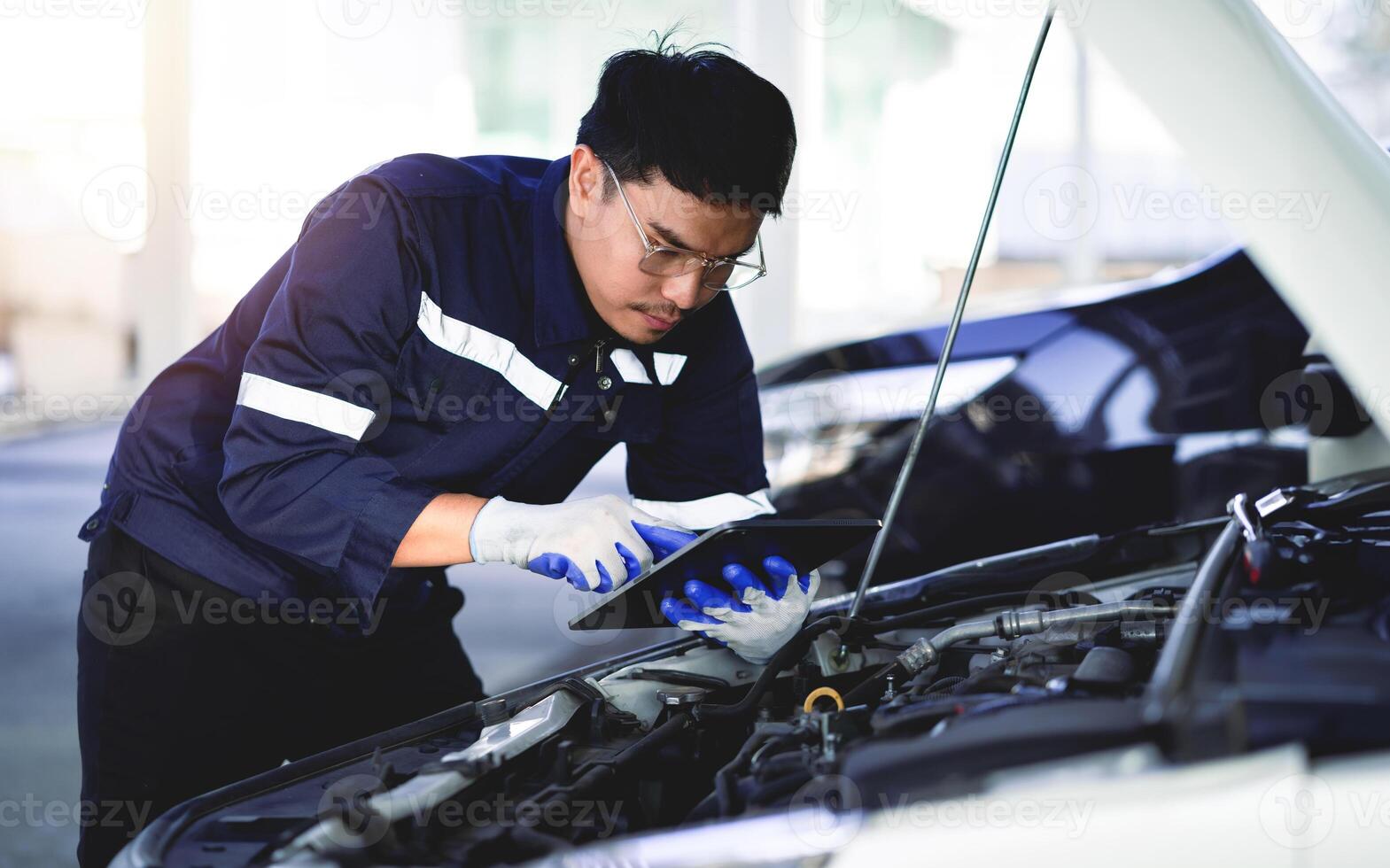 de monteur opent de kap van de auto naar inspecteren de motor voor schade en uitvoeren professioneel onderhoud. en inspecteert en reparaties zijn auto in de onderhoud centrum. foto