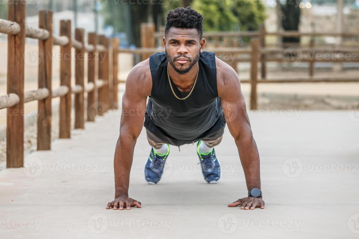 sterk sportman aan het doen plank in stad park foto