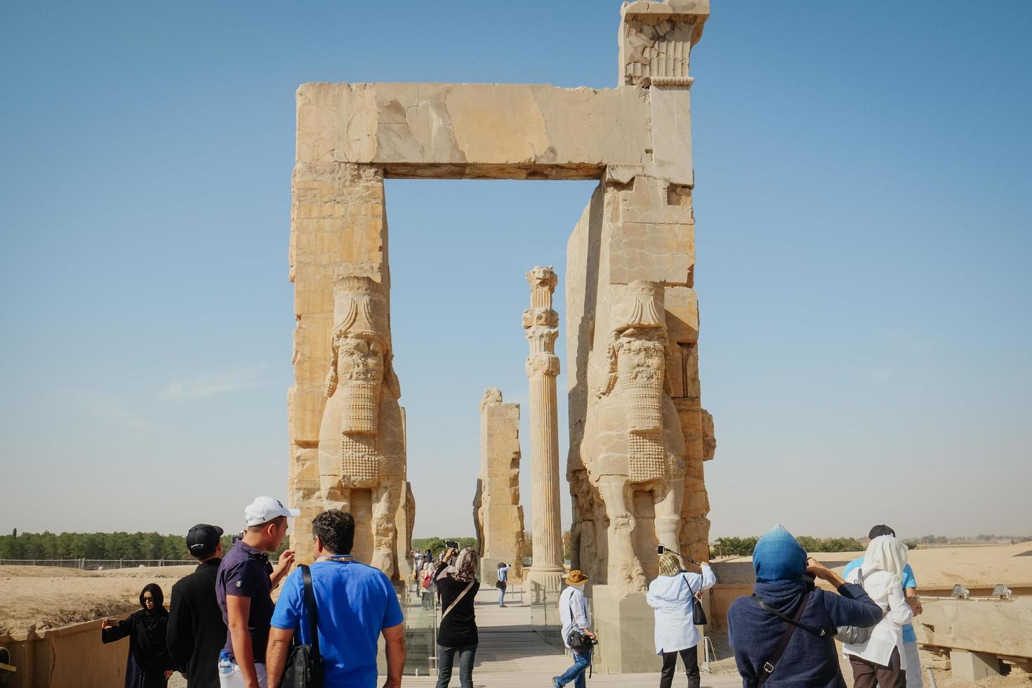 marvdasht, farsprovince, iran, 2016 - toeristen genieten van sightseeing en wandelen door de ruïnes van de oude poort van alle naties, persepolis. UNESCO werelderfgoed. foto