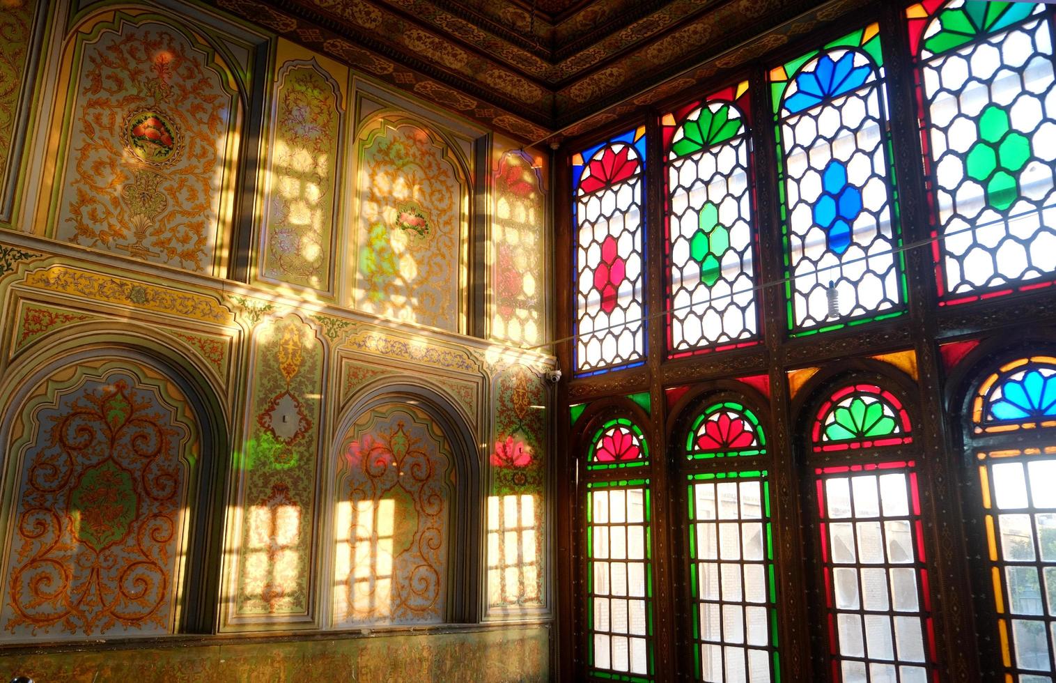 Shiraz, Iran, 2016 - prachtige binnenkamer verlicht met zonnestralen door kleurrijke glas-in-loodramen die kleuren reflecteren op de muur in Qavam House of Narenjestan e Ghavam foto