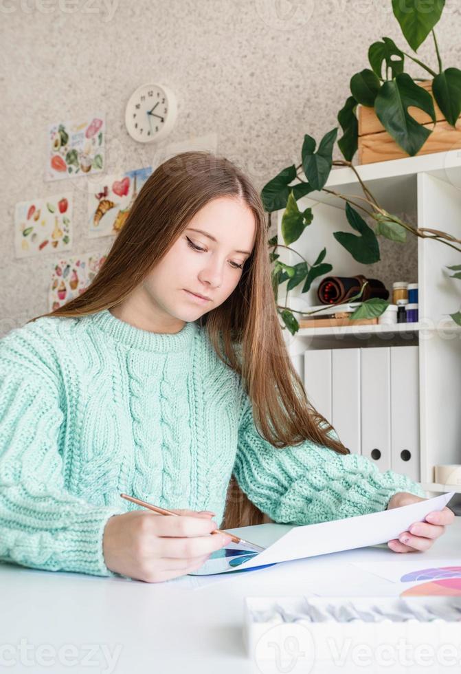 jonge lachende vrouw kunstenaar met kleurenpalet aan het werk in haar studio foto