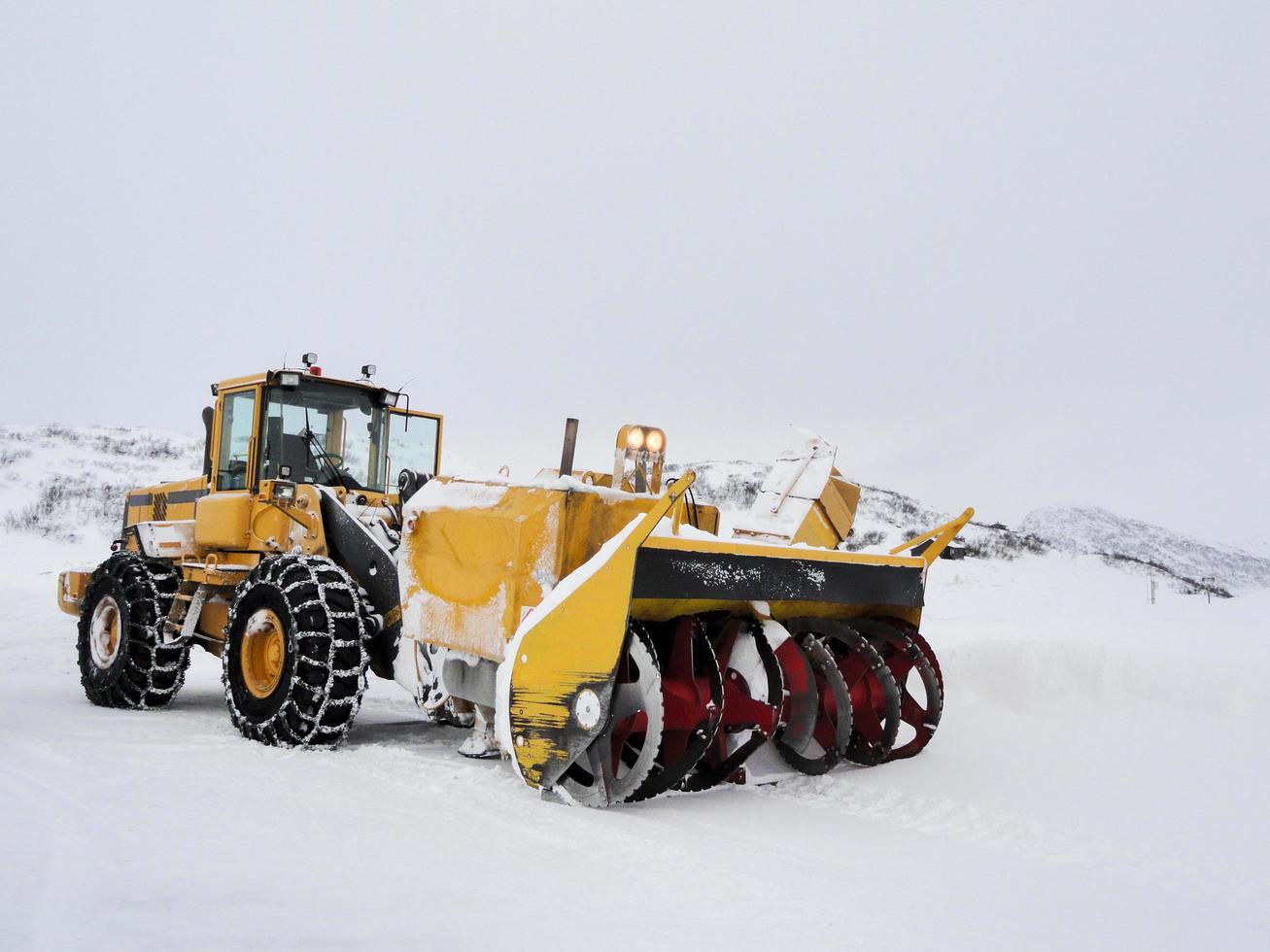 graafmachine sneeuwschop vrachtwagen op besneeuwde weg op het werk, noorwegen. foto