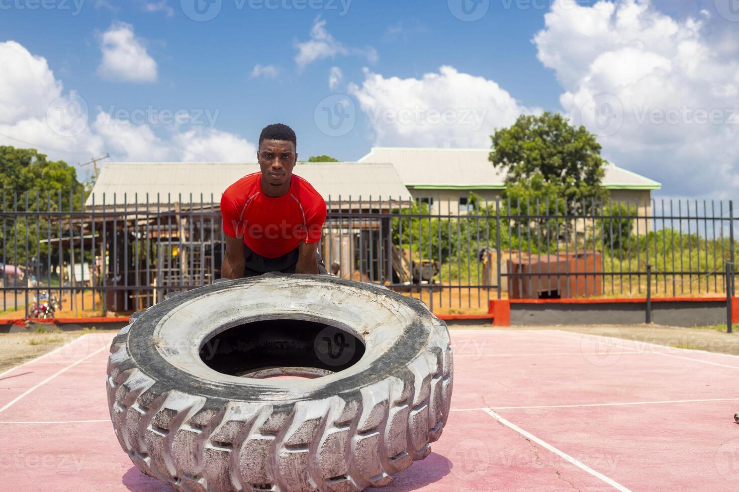 Afrikaanse atletisch Mens hijs- een groot Sportschool band in Sportschool foto