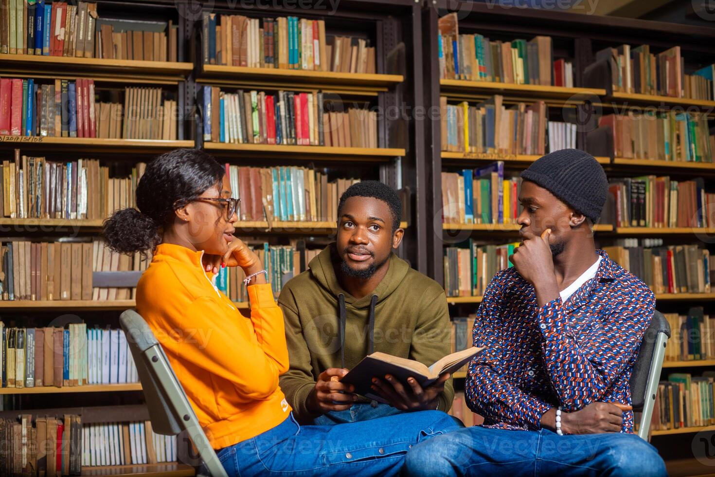 mensen, kennis, onderwijs en school- concept - groep van studenten lezing boeken en voorbereidingen treffen naar tentamen in bibliotheek foto