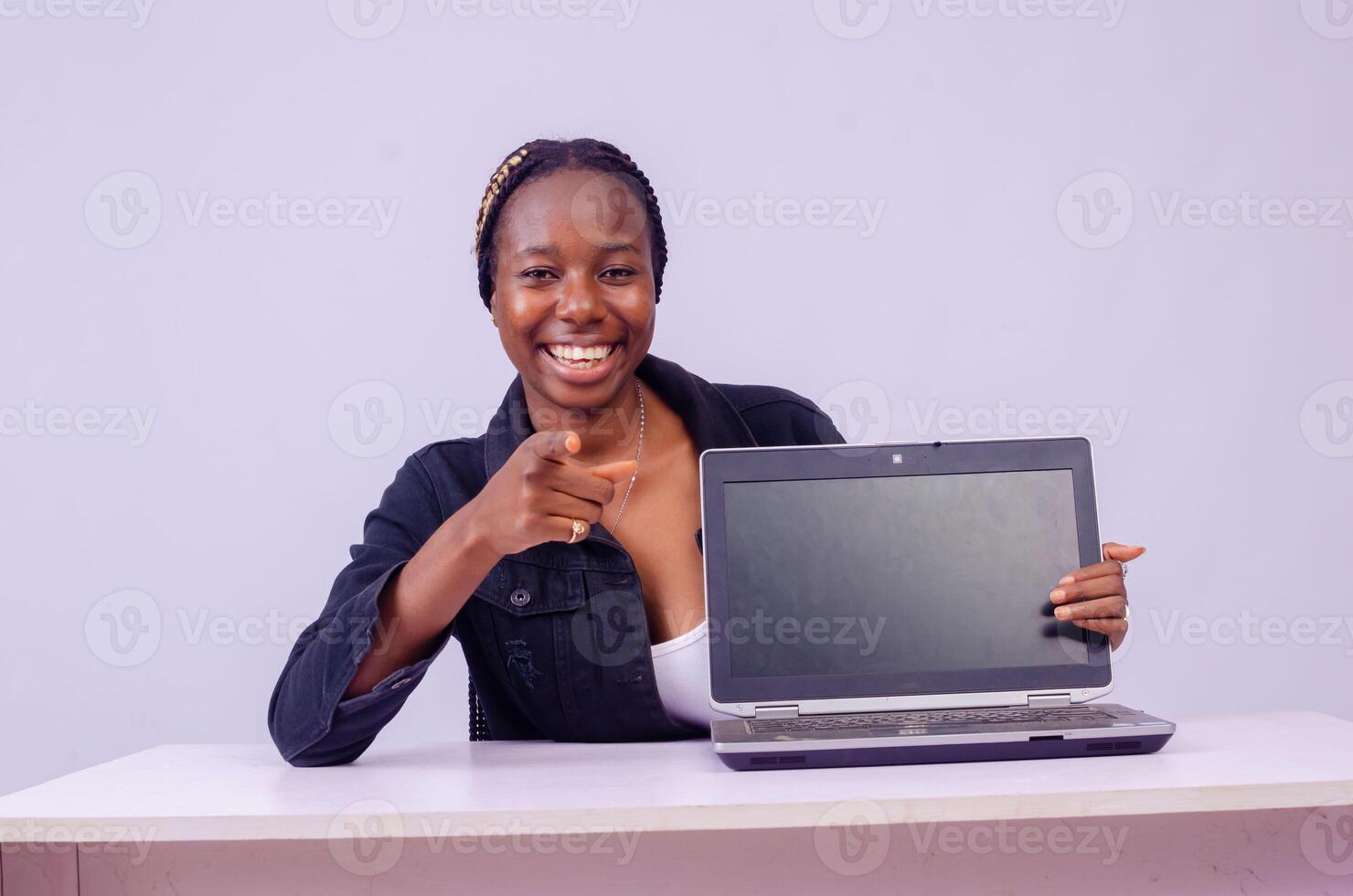 portret van een mooi jong zwart vrouw tonen haar laptop scherm foto