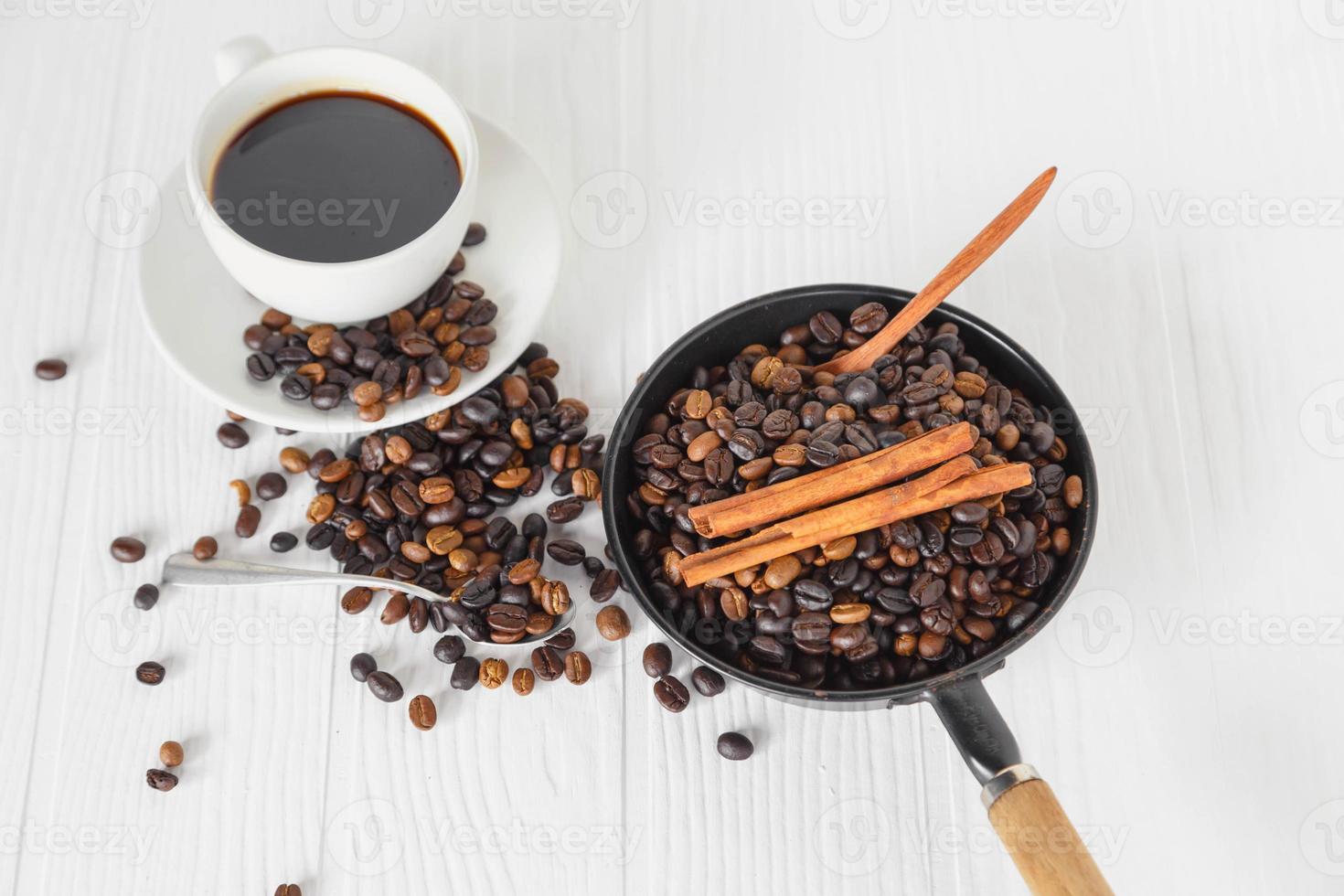 koffiekopje en koffieboon op witte houten tafel foto