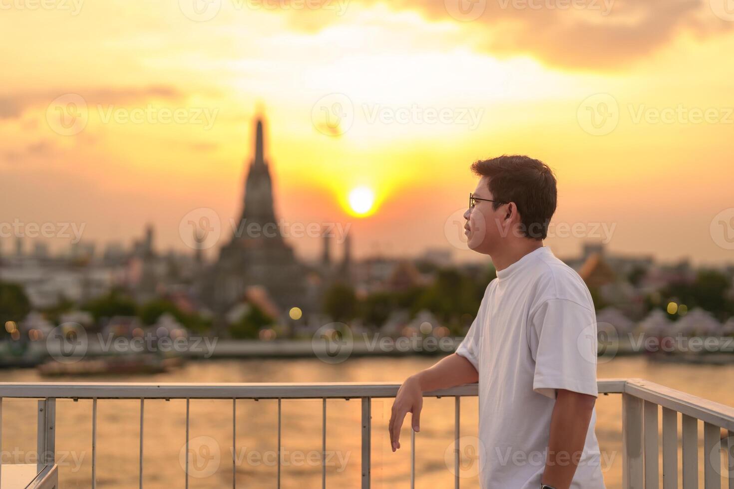 toerist Mens geniet visie naar wat arun tempel in zonsondergang, reiziger bezoeken tempel van dageraad in de buurt chao phraya rivier- van op het dak bar. mijlpaal en reizen bestemming in Bangkok, Thailand en zuidoosten Azië foto