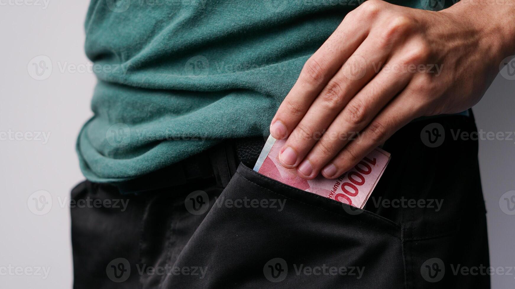 een man's hand- is zetten geld in zijn broek zak- foto