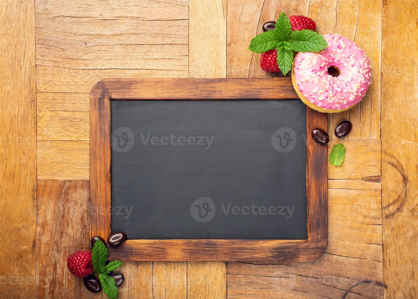 zwart krijtbord met roze geglazuurde donut foto