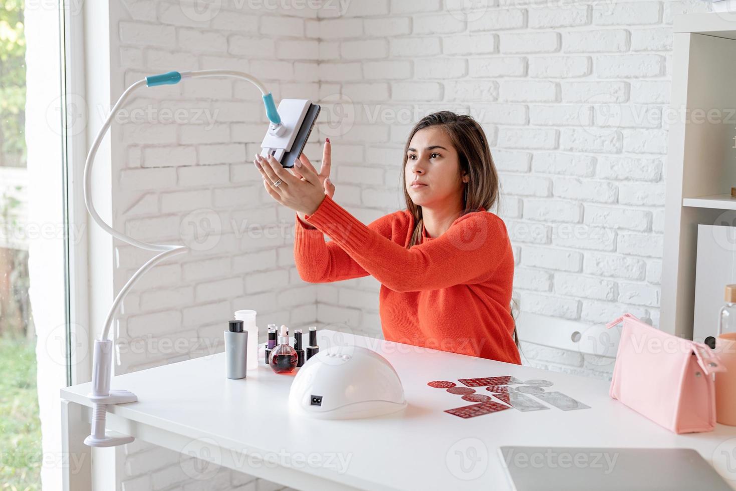 mooie blanke nagelmeester-beïnvloeder die videochat of een blog maakt foto