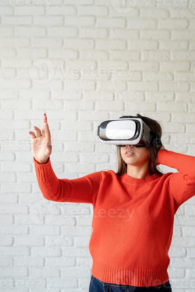glimlach gelukkige vrouw ervaring opdoen met vr-headset bril van virtual reality thuis veel gebarende handen foto