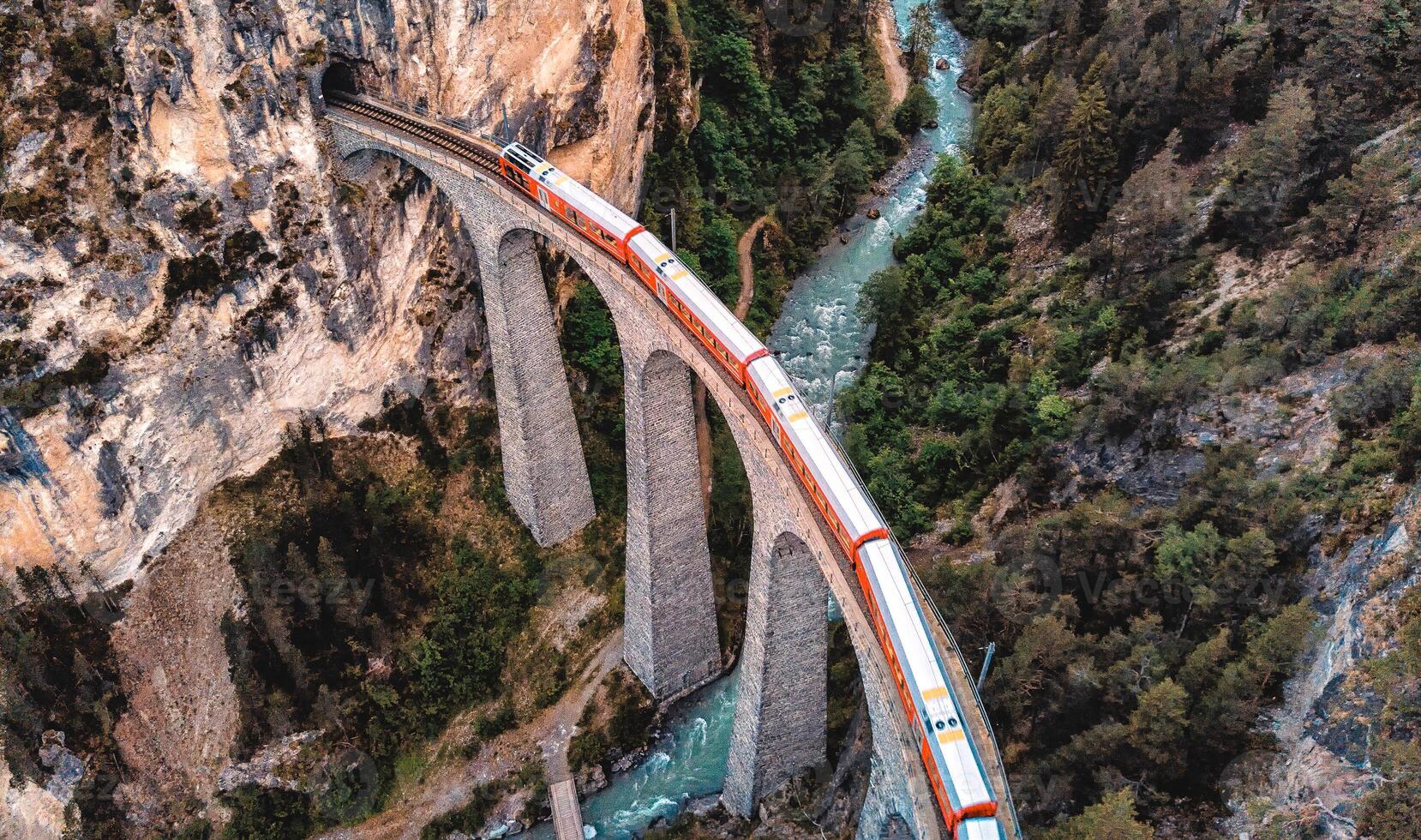 landwasserviadukt na zonsondergang. voorbijgaan rood Zwitsers trein over- beroemd UNESCO brug in Zwitserland, graubunden, filisur. foto