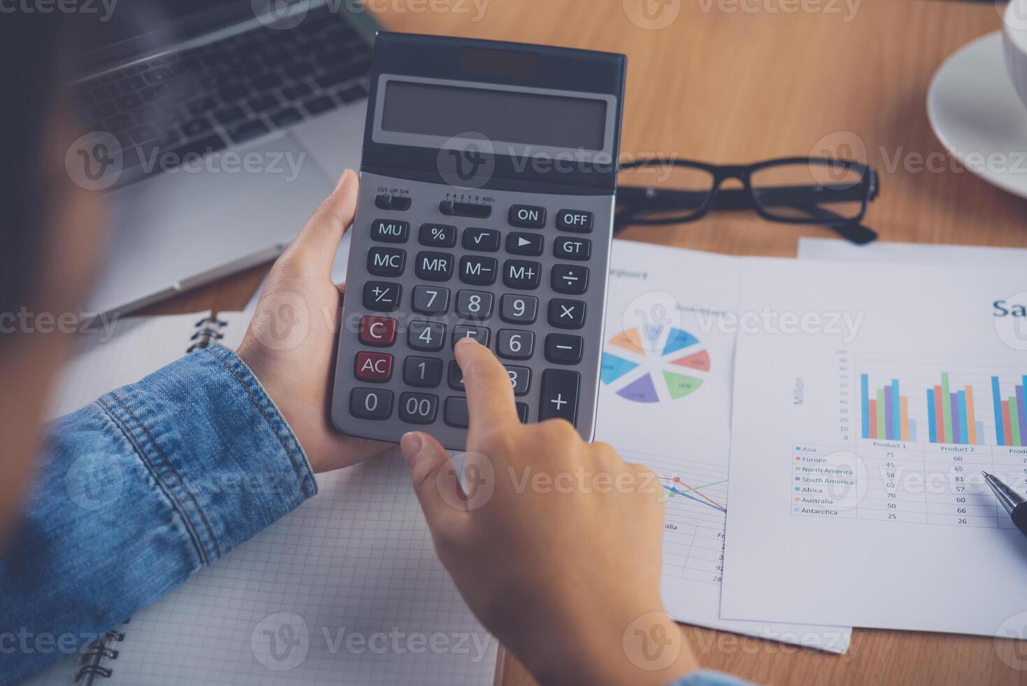 de accountant hand- is gebruik makend van de rekenmachine. voor kosten analyse winst en verlies en belasting berekening concept voorbereiding van financieel verklaringen foto