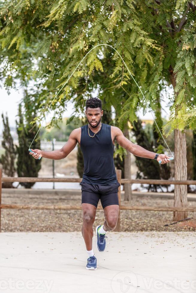 gespierd zwart atleet werken uit met jumping touw foto