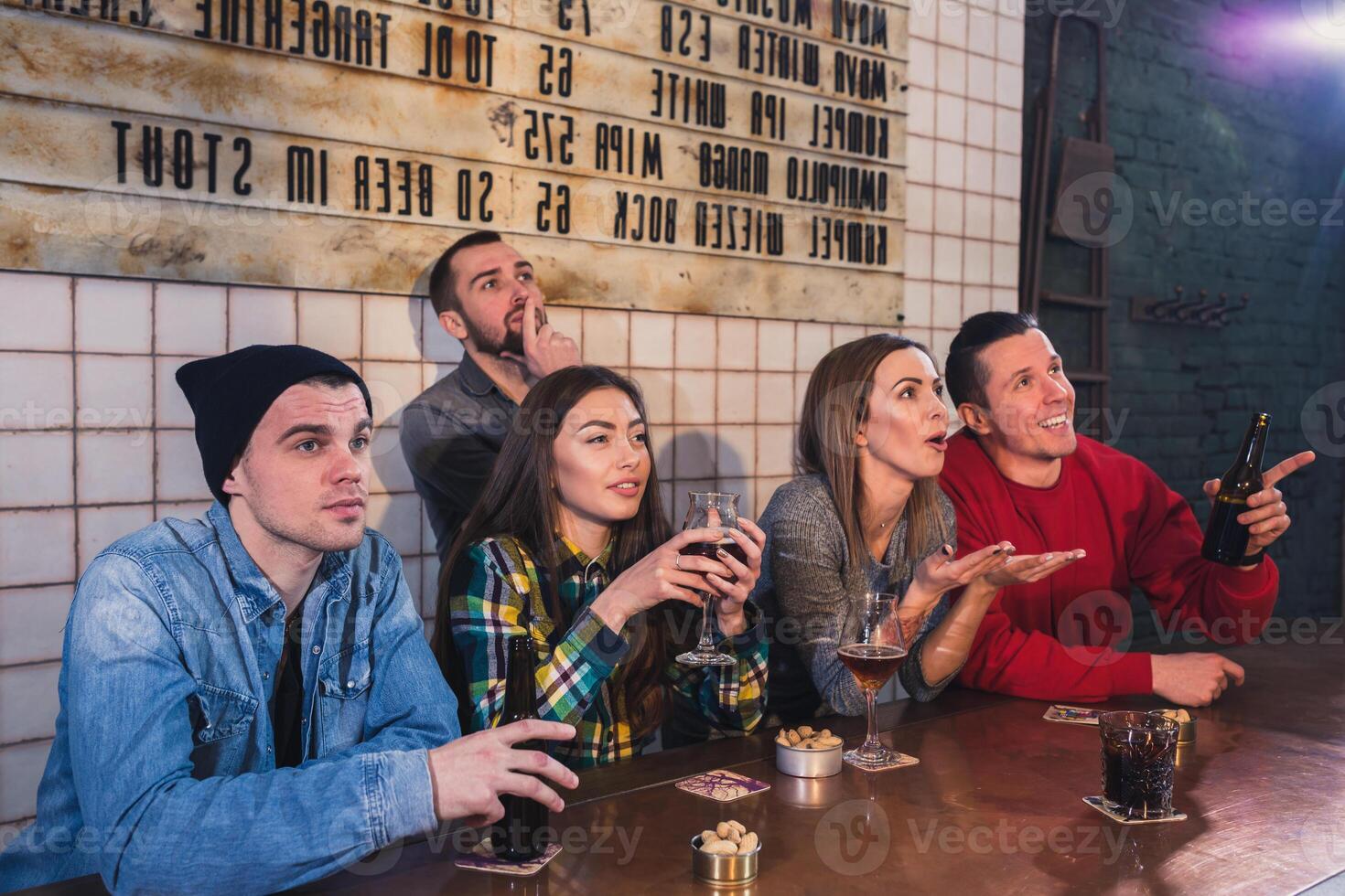 groep van jong mooi vrienden aan het kijken TV en juichen voor th foto