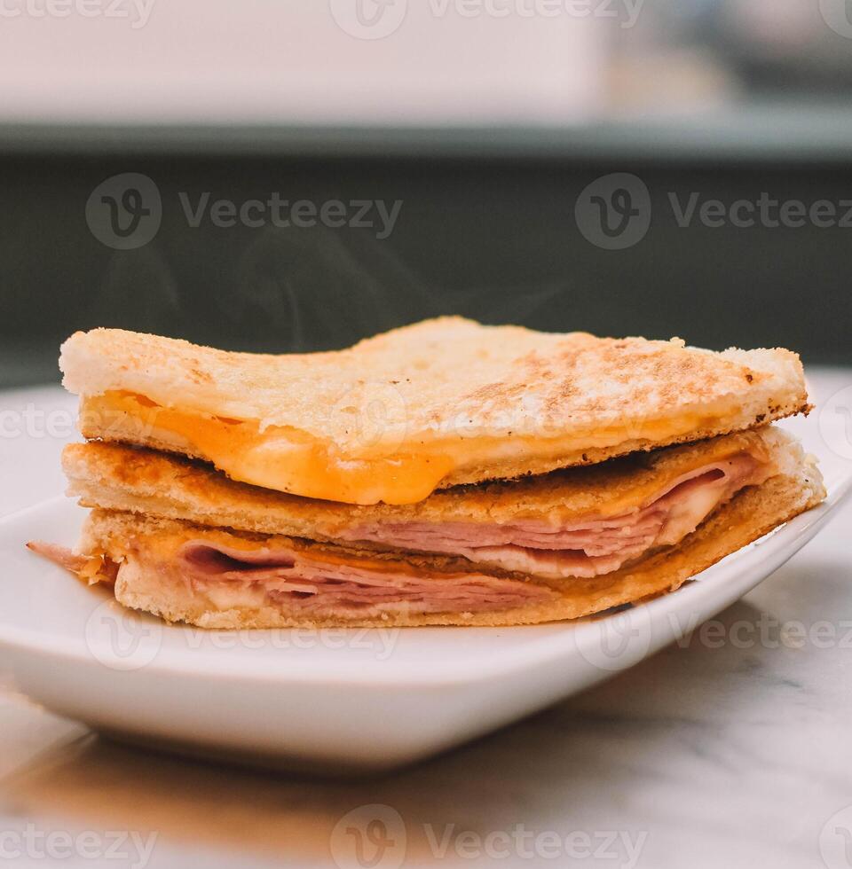 heet ham en kaas broodje, geroosterd met boter Aan brood foto