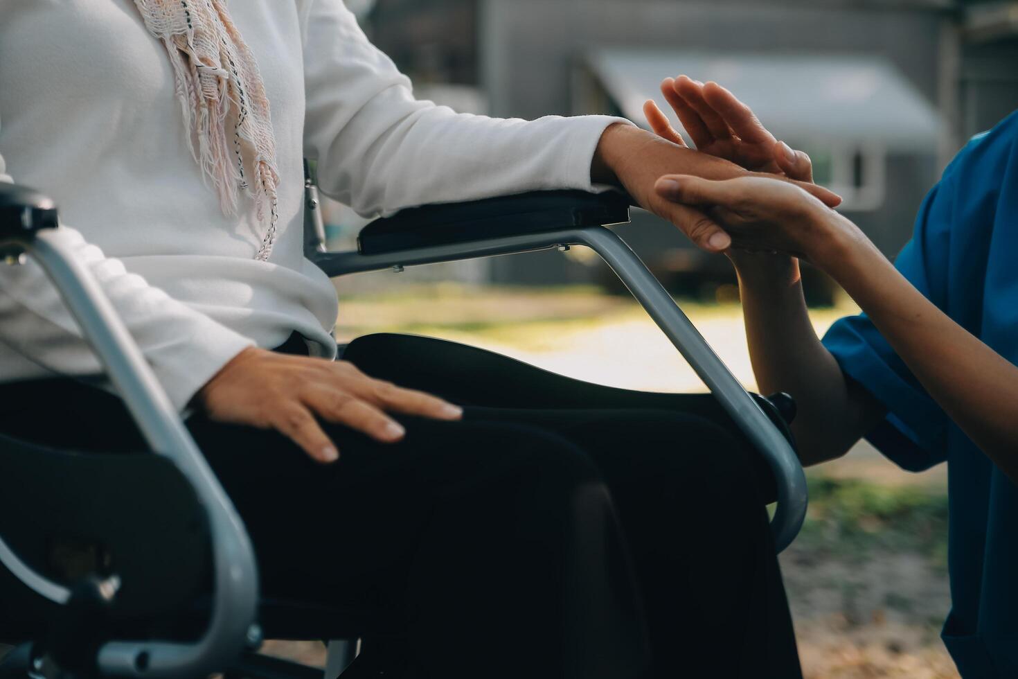 een verpleegster nemen zorg een senior mannetje Aan rolstoel in zijn tuin Bij huis foto