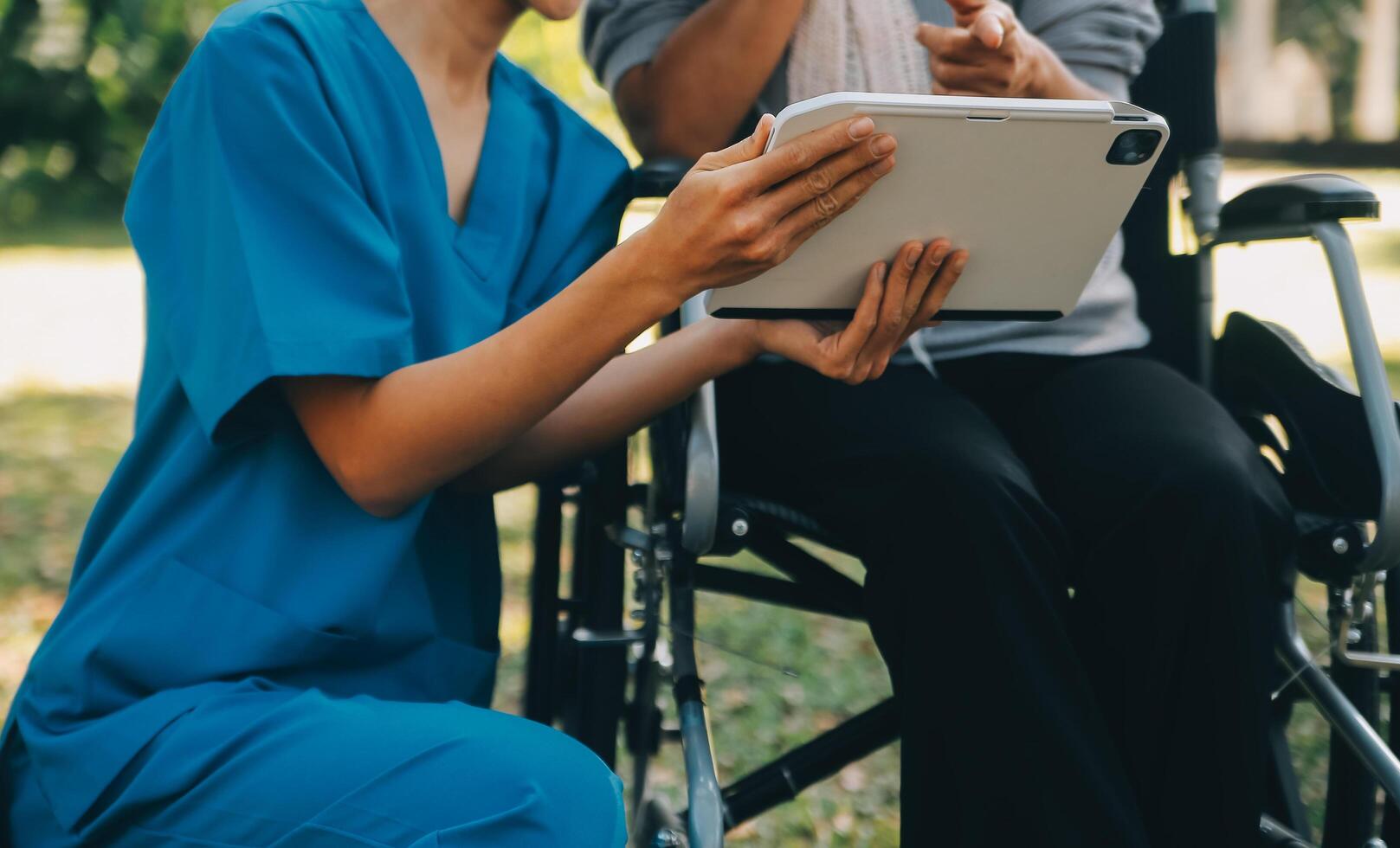 ouderen Aziatisch senior vrouw Aan rolstoel met Aziatisch voorzichtig verzorger en aanmoedigen geduldig, wandelen in tuin. met zorg van een verzorger en senior Gezondheid verzekering in zon licht foto