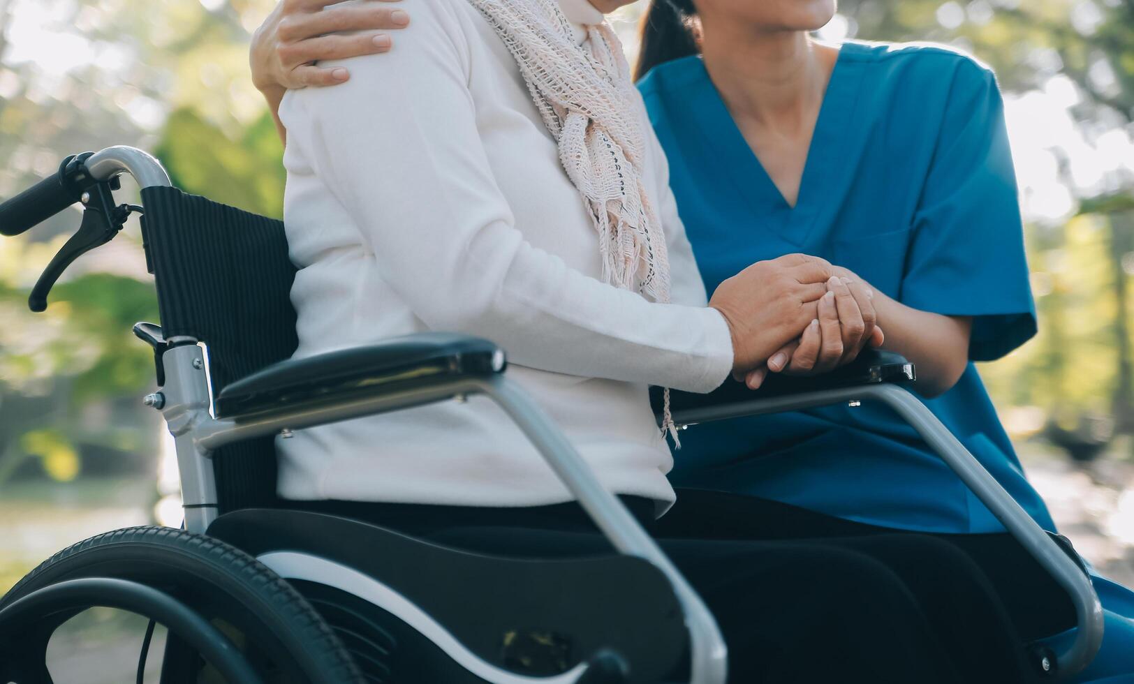 een verpleegster nemen zorg een senior mannetje Aan rolstoel in zijn tuin Bij huis foto