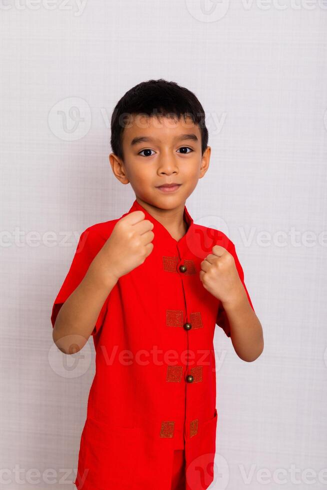 weinig jongen mode glimlachen kind in rood Chinese jurk, stijl en mode ideeën voor kinderen. Chinese nieuw jaar foto