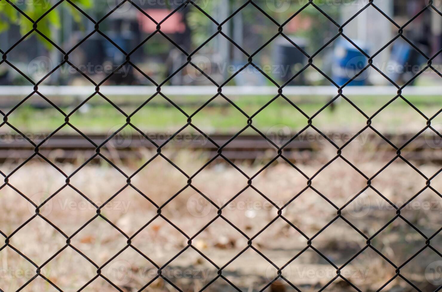 metaal maas draad hek met vervagen fabriek achtergrond foto