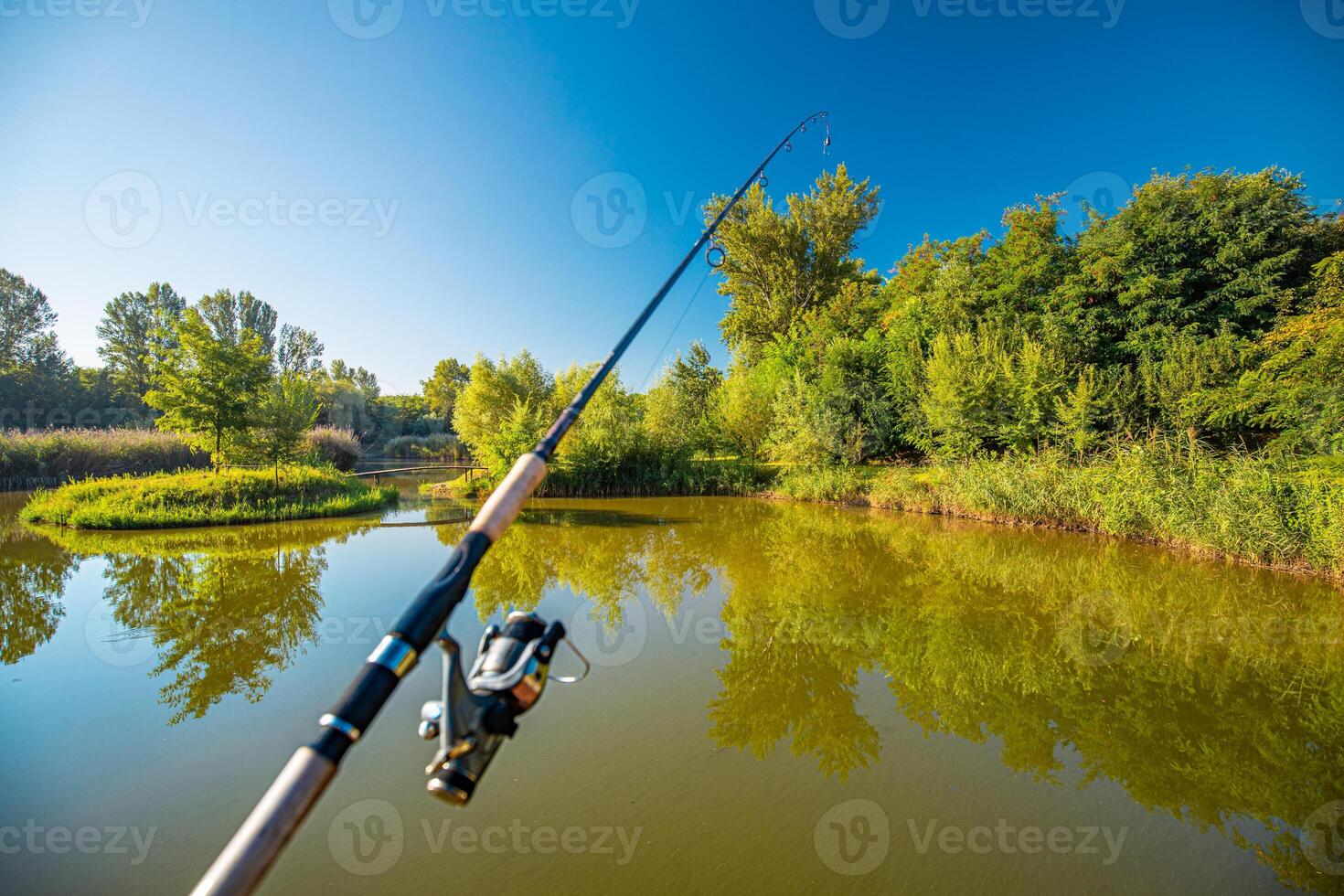 spinnen en meer. visvangst met hengel Aan meer, kalmte meer water reflectie, groen Woud en blauw lucht. kalmte ontspannende het weer, recreatief en buitenshuis sport achtergrond foto