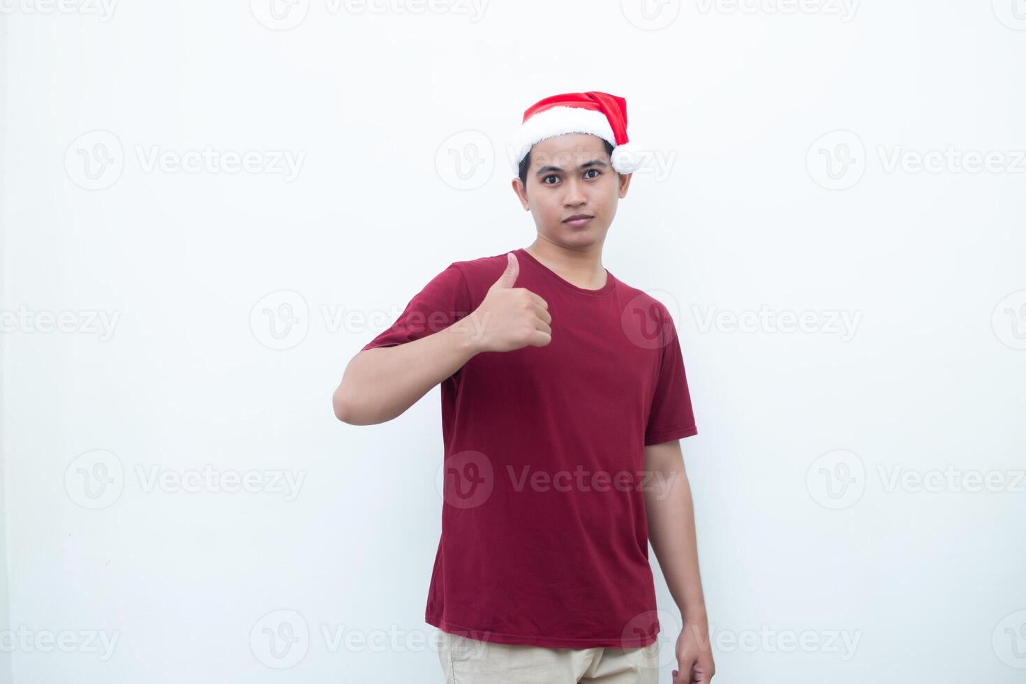 jong Aziatisch Mens vervelend een de kerstman claus hoed lachend, schok en richten naar haar kant geïsoleerd door wit achtergrond voor zichtbaar communicatie foto